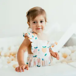 baby girl smiling in ball pit